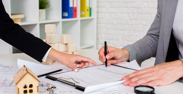 Two people signing a real estate contract or loan agreement